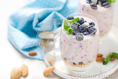 Greek yogurt or blueberry parfait with fresh berries and almond nuts on white background Stock Photo