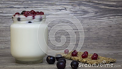 Greek yogurt, milk, smoothies, blueberries and currants in a glass jar on a wooden table, detox, diet Stock Photo