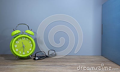Green alarm clock spectacle with the bunch of books Stock Photo