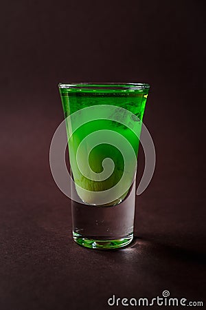 Green alcoholic shot glass with absent, irish cream, liquor on e Stock Photo