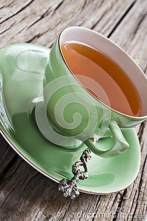 Green antique tea cup with healthy organic tea Stock Photo