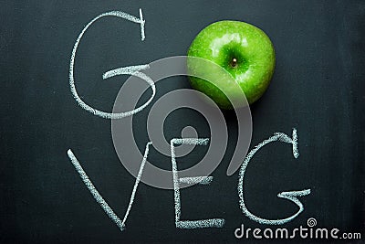 Green Apple on Black Chalkboard Hand Lettering Go Veg. Vegan Vegetarian Concept Healthy Diet Superfood. Stock Photo