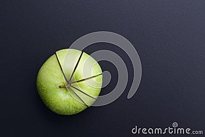 Green apple cutting in the shape of pie chart on back board. Stock Photo