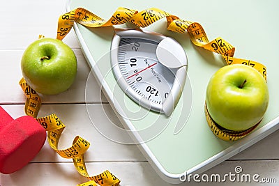 Green apple with weight scale and measuring tape for the healthy diet slimming Stock Photo