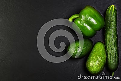 Green assortment vegetables, avocados, pepper and cucumber on a shale board, the concept of healthy eating, copy space, top view s Stock Photo