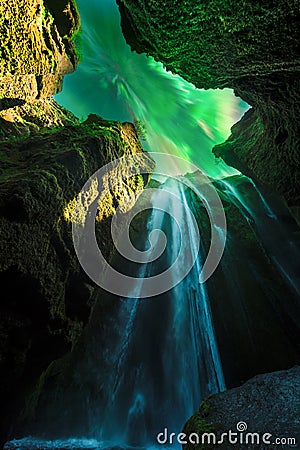 Green aurora light behind unique Gljufrabui waterfall Stock Photo