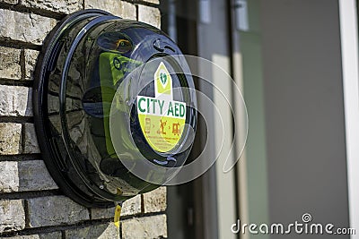 Green automated external defibrillator CITY AED on the street in the city Editorial Stock Photo