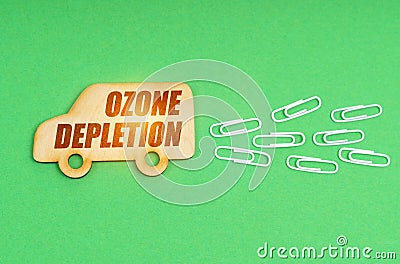 On a green background, a wooden truck with the inscription - ozone depletion Stock Photo