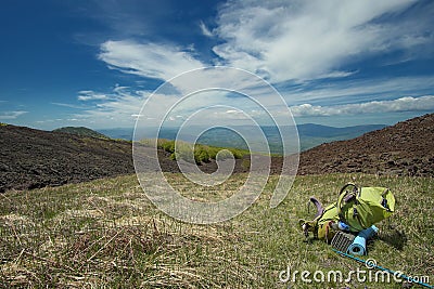 Green Backpack In Mountain Landscape Stock Photo