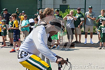 Green Bay Packer Player Riding Bike with Young Fan Editorial Stock Photo