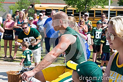 Green Bay Packer Player Riding Bike with Young Fan Editorial Stock Photo