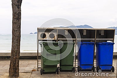 Green and blue bin for different collection Of Recycle Materials on footpath near beach Stock Photo