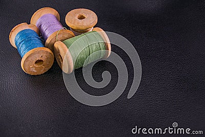 green blue purple white bobbins threads on black skin copyspace Stock Photo