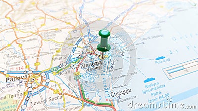 A green board pin stuck in Venice on a map of Italy Stock Photo