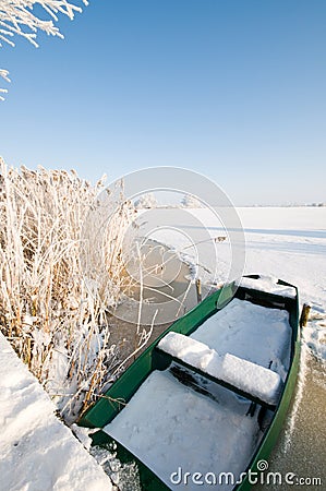 Green boat on ice in winter landscape Stock Photo