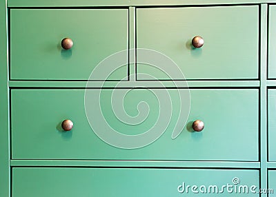 Green cabinet with various drawers, colorful wooden closet close-up retro design background texture Stock Photo