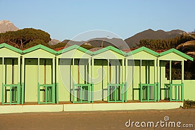 Green cabins in a neat, geometric row. Italian bathhouse in Tuscany on the beach by the sea Stock Photo
