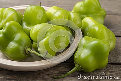 Green cambuci pepper, brazilian cuisine ingredient, on a plate over wooden table Stock Photo