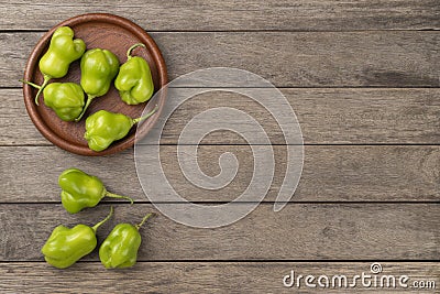 Green cambuci peppers on a plate over wooden table with copy space Stock Photo