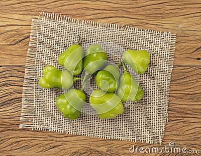 Green cambuci peppers on a rustic fabric over wooden table. Typical brazilian ingredient Stock Photo