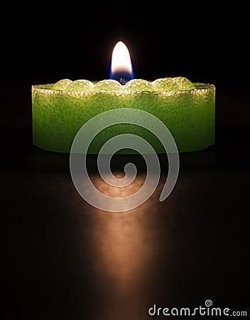 Green candle on a dark background Stock Photo