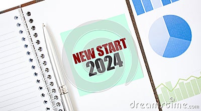 Green card on the white notepad. Text NEW START 2024. Business concept Stock Photo
