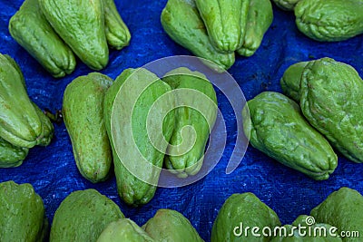 Green chayote pile. Ripe vegetable on market. Tropical vegetable for soup or side dish. Green vegetable gourt Stock Photo