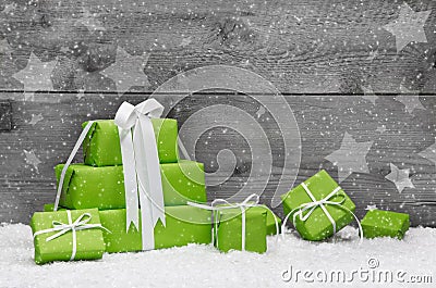 Green Christmas presents with snow on grey wooden background for Stock Photo
