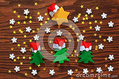Green Christmas trees and a yellow star, in Santa hats. white snowflakes and yellow little stars. Stock Photo
