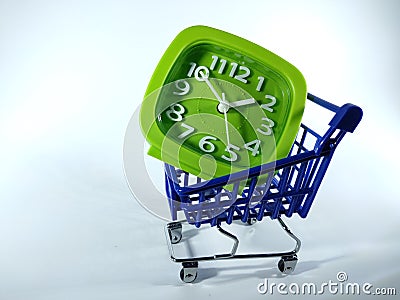 Green clock inside blue shopping trolly isolated on a white background. Stock Photo