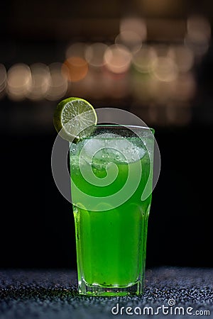 green cocktail with lime garnish in a tall glass Stock Photo