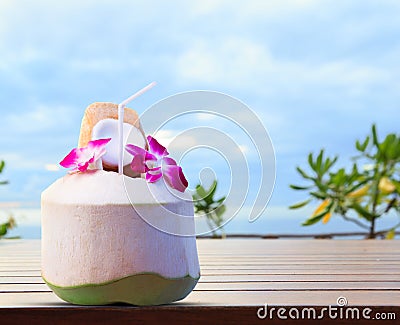 Green coconut and orchid flowers as welcome drink in tropical de Stock Photo