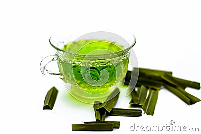 Green colored tea of lemon grass in a transparent cup isolated on white used in many ayurvedic treatments. Stock Photo