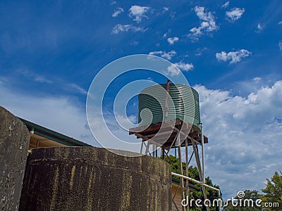 Green Corrugated water tank with blue sky Stock Photo