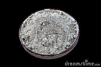 Green cosmetic clay powder in ceramic container on black background crop Stock Photo