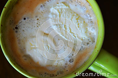 A green cup of coffee with ice-cream on top Stock Photo