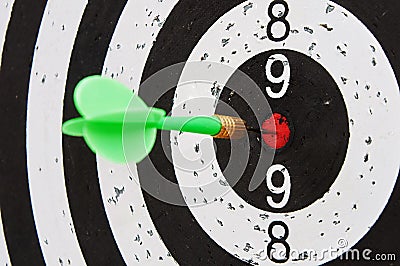 Green dart hits the center zone of target Stock Photo