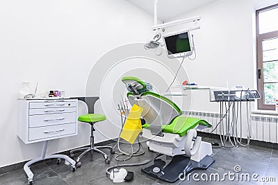 Green dental chair and medical equipment at the dental clinic. The concept of healthcare and treatment in medical Stock Photo