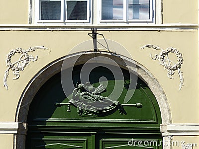 Green door with an engraved sculpture of a winged goddess to Budapest in Hungary. Editorial Stock Photo