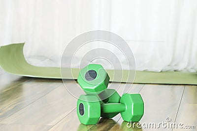 Green dumbbells and mat for workout indoor.Concept of training at home and getting stronger Stock Photo