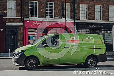 Green electric Royal Mail van on a street in London, UK Editorial Stock Photo