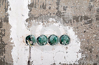 Green electrical sockets embedded in a concrete wall, close-up Stock Photo
