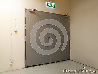 green emergency exit sign to install over the door building construction showing the way to escape Stock Photo