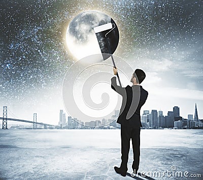 Green energy concept with businessman cleans the Moon at city ba Stock Photo