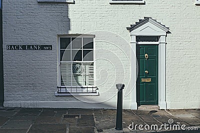 Green entrance door on a facade of a British terrace house in London Editorial Stock Photo