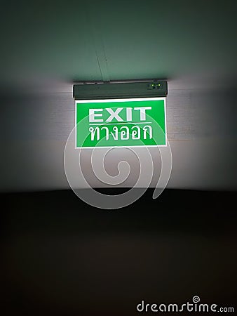 Green Exit Sign,Emergency exit sign glowing in the dark Stock Photo