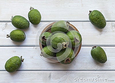 Green feijoa fruits in a cork plate on a light white wooden table. Tropical fruit feijoa. Set of ripe feijoa fruits. the view from Stock Photo