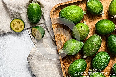 Green feijoa fruits in a wooden plate on a grey background. Tropical fruit feijoa. Top view Stock Photo
