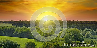 Green fields and bright sunrise. Wide photo. Agricultural landscape. Stock Photo