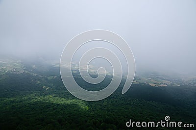 Fields among the fog in a valley whit forest Stock Photo
